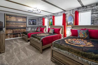 a bedroom with two beds and a stone wall at Luxury Lake View 9-Bedroom Villa @Storey Lake Resort in Kissimmee