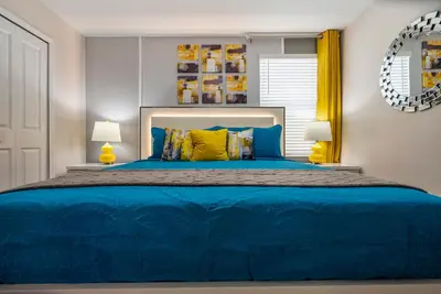a bedroom with a blue bed with two lamps at Luxury Lake View 9-Bedroom Villa @Storey Lake Resort in Kissimmee