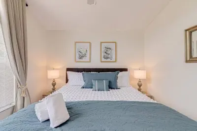 a bedroom with a bed with blue pillows and two lamps at 5 Bedroom villa with private pool, close to disney in Kissimmee