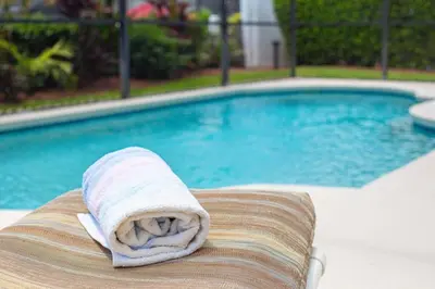 a towel sitting on a chair next to a swimming pool at 5 Bedroom villa with private pool, close to disney in Kissimmee