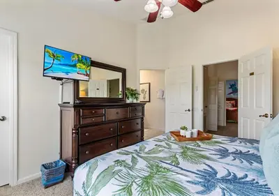 a bedroom with a bed with a television on a dresser at Lilo and stitch Ohana Oasis in Kissimmee