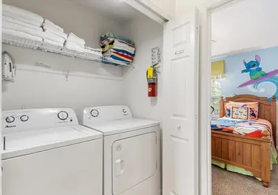a laundry room with a washer and dryer and a bed at Lilo and stitch Ohana Oasis in Kissimmee