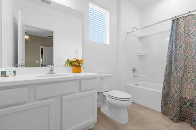 a white bathroom with a toilet and a sink and a tub at 30-Guest Home w Theme Rooms Games Resort Access in Kissimmee