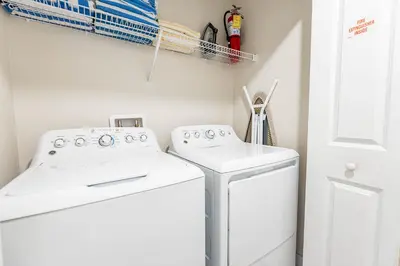 a laundry room with two washing machines and a door at Amazing Townhouse at Storey Lake Resort in Kissimmee