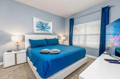 a bedroom with a blue bed with two towels on it at Amazing Townhouse at Storey Lake Resort in Kissimmee