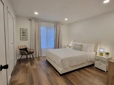 a bedroom with a bed and a chair and a window at Elegant Cozy Spot to unwind! UCF/MCO/Parks/Beach in Orlando