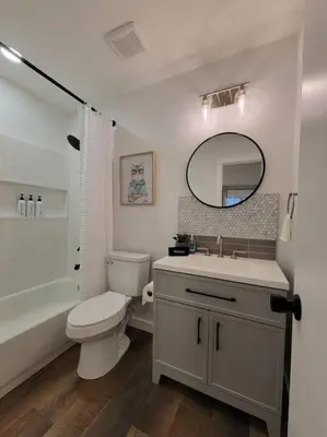a bathroom with a toilet and a sink and a mirror at Elegant Cozy Spot to unwind! UCF/MCO/Parks/Beach in Orlando
