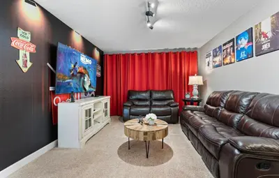 a living room with a leather couch and a table at Amazing 6Bdrms At Storey Lake- Close to Disney in Kissimmee