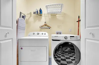 a laundry room with a stove and a washing machine at South Facing Pool with Spa and a Game Room in Prime Location Near Disney in Kissimmee