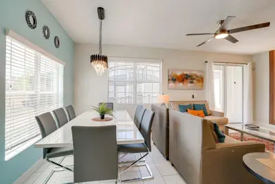 a dining room and living room with a table and a couch at Kissimmee Getaway with Pool Access 5 Mi to Disney in Kissimmee