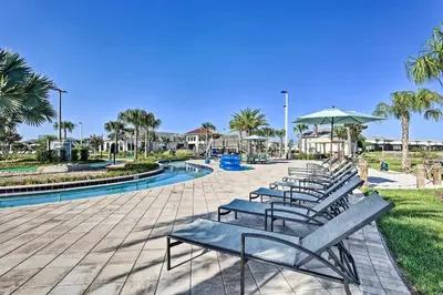 a row of benches sitting next to a pool at Kissimmee Getaway with Pool Access 5 Mi to Disney in Kissimmee