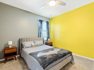 a bedroom with a bed and a yellow wall at 6BR w Heated Pool + 9MI to Disney + Sleeps 14 in Kissimmee