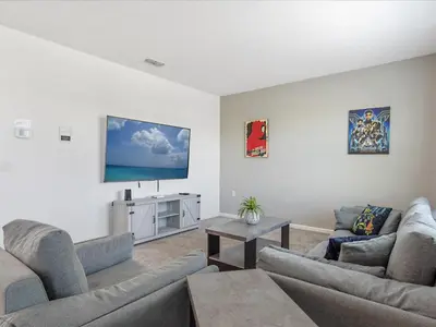 a living room with two couches and a flat screen tv at 6BR w Heated Pool + 9MI to Disney + Sleeps 14 in Kissimmee
