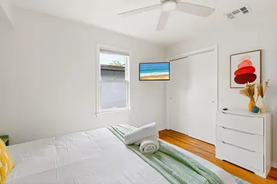 a white bedroom with a bed and a ceiling fan at Fire Pit + Grill + 2MI to DT Orlando in Orlando