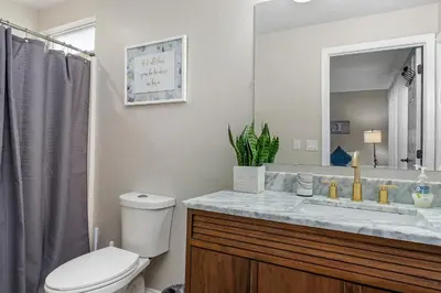a bathroom with a toilet and a sink with a mirror at 4BR w Heated Pool near Disney & Lake - Sleeps 10 in Kissimmee