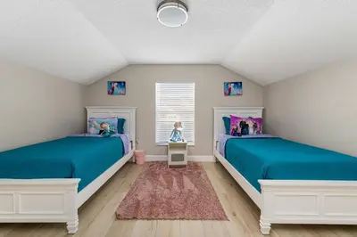 two beds in a room with blue and white at 4BR w Heated Pool near Disney & Lake - Sleeps 10 in Kissimmee