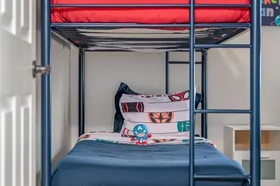 a bedroom with a bunk bed with blue sheets at 4BR w Heated Pool near Disney & Lake - Sleeps 10 in Kissimmee