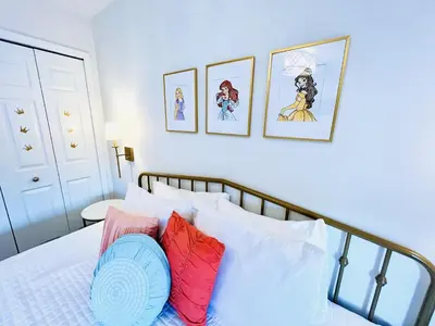 a bedroom with a bed with four pictures on the wall at Enchanted Hideaway in Kissimmee