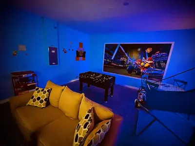 a living room with a couch and a flat screen tv at Enchanted Hideaway in Kissimmee