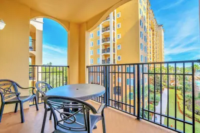 a balcony with a table and chairs and a building at Cozy 2BR Condo Resort Spa with Pirate Pool in Kissimmee