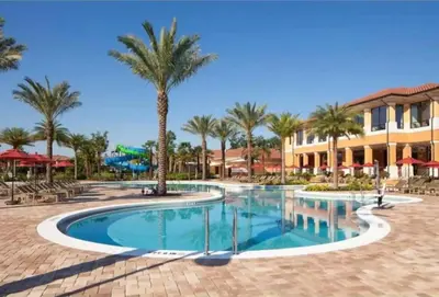 a swimming pool with palm trees and a building at Comfortable 3BdrmsPrivate Hot TubClose to Disney in Kissimmee