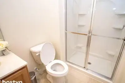 a bathroom with a toilet and a glass shower at Beautiful Townhome w Hot Tub Near Disney in Kissimmee