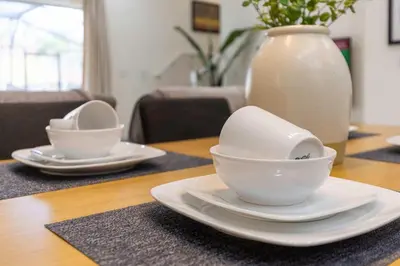 a table with two white plates and a vase at Amazing Townhouse for 6 people near Disney in Kissimmee