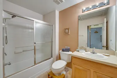 a bathroom with a toilet and a sink and a shower at 4 Mi to Disney Emerald Island Resort Home! in Kissimmee