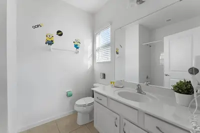 a bathroom with a sink and a toilet and a mirror at Last Minute Disney Private Pool Hot Tub Game Room Themed Bedrooms. Book Now 43123 in Kissimmee