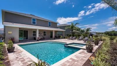 a swimming pool in the backyard of a house at Last Minute Disney Getaway! Private Pool, Hot Tub & Games Room. Book Now! #60535 in Orlando