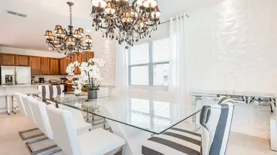 a dining room with a glass table and white chairs at Last Minute Disney Getaway! Private Pool, Hot Tub & Games Room. Book Now! #60535 in Orlando