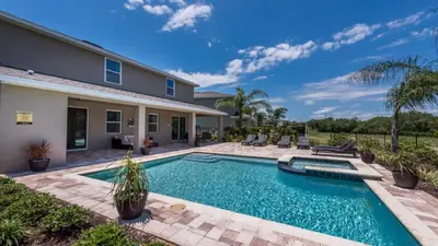 a swimming pool in the backyard of a house at Last Minute Disney Getaway! Private Pool, Hot Tub & Games Room. Book Now! #60535 in Orlando
