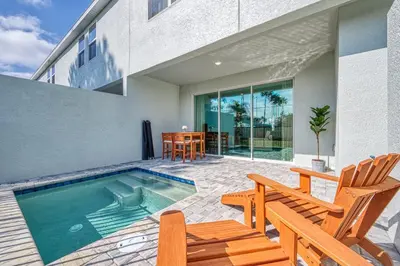 a swimming pool with two chairs and a table at Last Minute Disney Getaway Private Pool Themed Bedrooms. Book Now 81931 in Orlando
