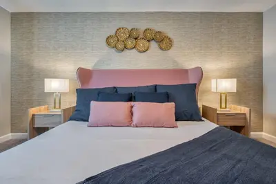 a bedroom with a large bed with blue and pink pillows at Last Minute Disney Getaway Private Pool Themed Bedrooms. Book Now 81931 in Orlando