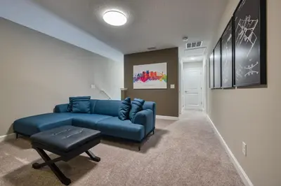 a living room with a blue couch and a stool at Last Minute Disney Getaway Private Pool Themed Bedrooms. Book Now 81929 in Orlando
