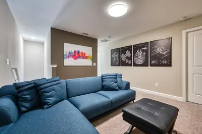a living room with a blue couch in a room at Last Minute Disney Getaway Private Pool Themed Bedrooms. Book Now 81925 in Orlando
