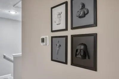 a group of framed pictures on a wall at Last Minute Disney Getaway Private Pool Themed Bedrooms. Book Now 81953 in Orlando