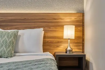 a bed with a wooden headboard and a lamp on a table at Last Minute Disney Getaway Private Pool Themed Bedrooms. Book Now 81917 in Orlando