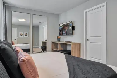 a bedroom with a bed and a desk and a mirror at Last Minute Disney Getaway Private Pool Themed Bedrooms. Book Now 81951 in Orlando