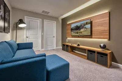 a living room with a blue couch and a tv at Last Minute Disney Getaway Private Pool Themed Bedrooms. Book Now 81895 in Orlando