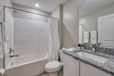 a white bathroom with a tub and a toilet and a sink at Last Minute Disney Getaway Private Pool Themed Bedrooms. Book Now 81895 in Orlando