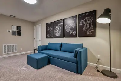 a living room with a blue couch and a lamp at Last Minute Disney Getaway Private Pool Themed Bedrooms. Book Now 81945 in Orlando