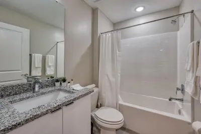a white bathroom with a toilet and a sink at Last Minute Disney Getaway Private Pool Themed Bedrooms. Book Now 81945 in Orlando