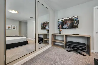 a bedroom with a bed and a desk and a mirror at Last Minute Disney Getaway Private Pool Themed Bedrooms. Book Now 81943 in Orlando