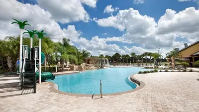 a pool at a resort with a water slide at Last Minute Disney Getaway! Private Pool, Hot Tub & Games Room. Book Now! #56201 in Kissimmee