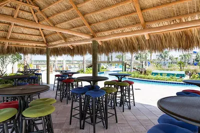 a patio with tables and chairs and a swimming pool at Storey Lake Resort 1020 - Hosted by Top Villas in Kissimmee