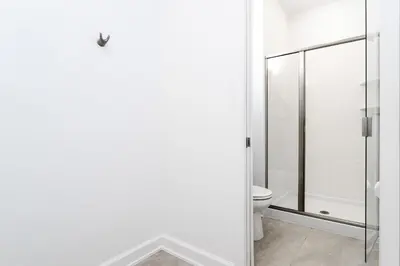 a bathroom with a toilet and a glass shower door at Last Minute Disney Getaway Private Pool Themed Bedrooms. Book Now 99589 in Kissimmee
