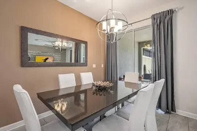 a dining room with a glass table and white chairs at Storey Lake Resort 1071 - Hosted by Top Villas in Kissimmee