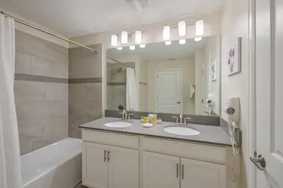 a bathroom with two sinks and a large mirror at Storey Lake Resort 1071 - Hosted by Top Villas in Kissimmee