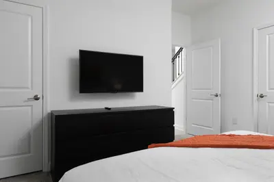 a bedroom with a black dresser with a tv on the wall at Storey Lake Resort 1083 - Hosted by Top Villas in Kissimmee